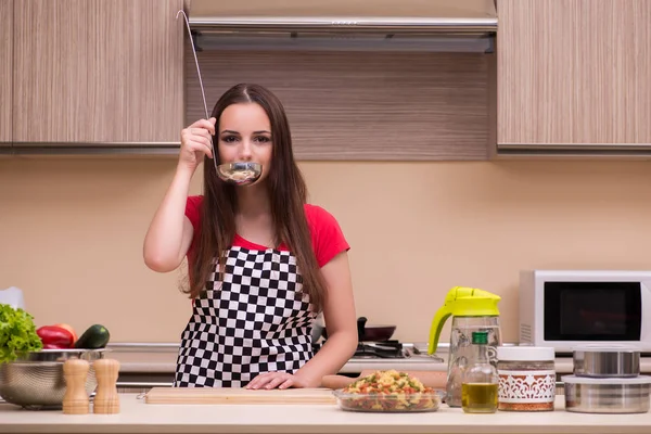 Молодая женщина домохозяйка работает на кухне — стоковое фото