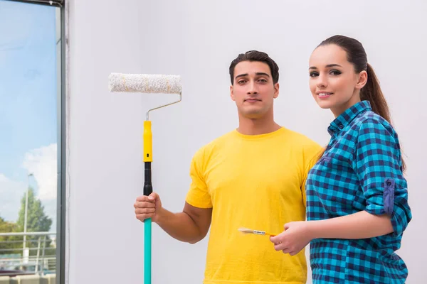 Jovem casal parede de pintura em casa — Fotografia de Stock