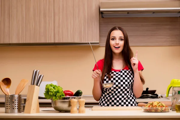 Young woman housewife working in the kitchen — Stock Photo, Image