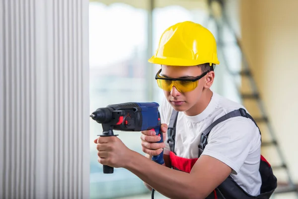 Uomo foratura del muro con perforatore — Foto Stock