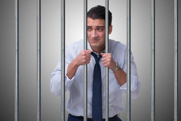 Young businessman behind the bars in prison — Stock Photo, Image