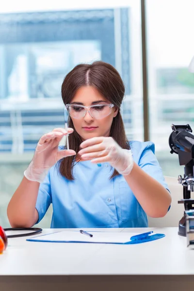 Giovane donna che lavora in laboratorio — Foto Stock