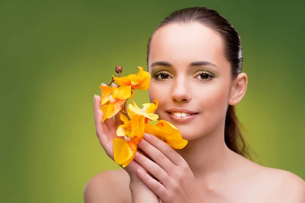 Beautiful woman with yellow orchid flower — Stock Photo, Image