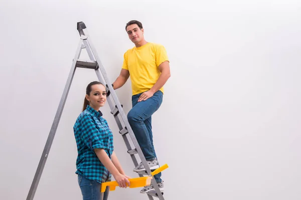 Jovem casal parede de pintura em casa — Fotografia de Stock