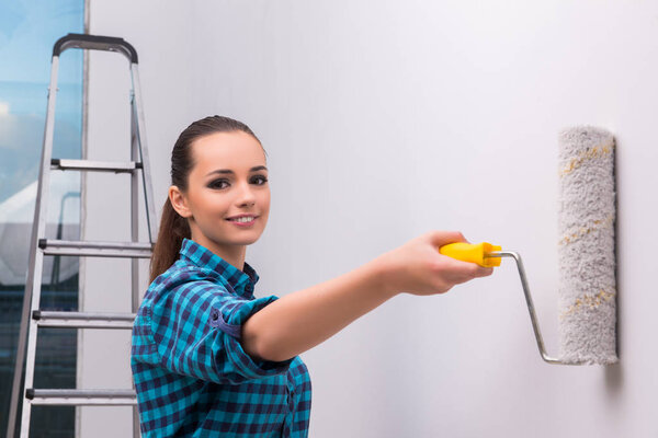 Woman painting house in DIY concept