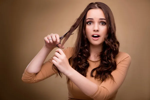 Hermosa mujer con tijeras cortando su cabello — Foto de Stock