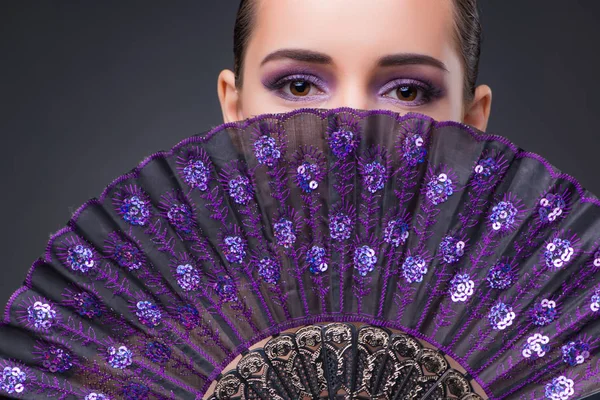 Nice woman with fan against gray background — Stock Photo, Image