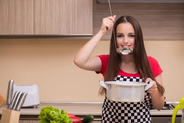 Mladá žena hospodyně v kuchyni — Stock fotografie