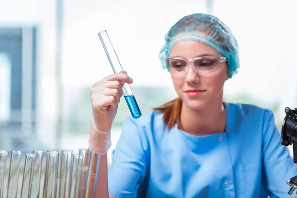 Jovem estudante trabalhando com soluções químicas em laboratório — Fotografia de Stock