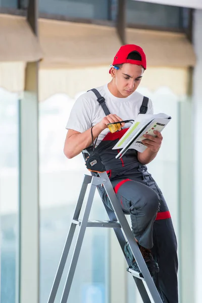 Молодой ремонтник проверяет чертежи перед началом работ — стоковое фото