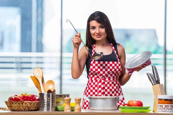 Kvinnliga kock förbereda soppa i ljust lit kök — Stockfoto
