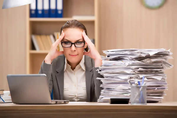 Zakenvrouw onder stress van teveel werken op kantoor — Stockfoto