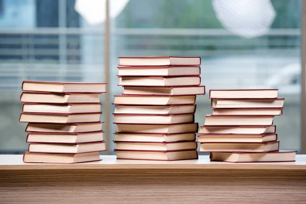 Pilha de livros arranjou a mesa de escritório — Fotografia de Stock