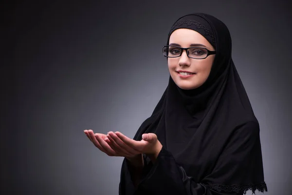 Muslimische Frau in schwarzem Kleid vor dunklem Hintergrund — Stockfoto