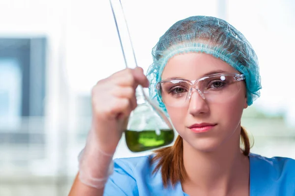 Jovem estudante trabalhando com soluções químicas em laboratório — Fotografia de Stock