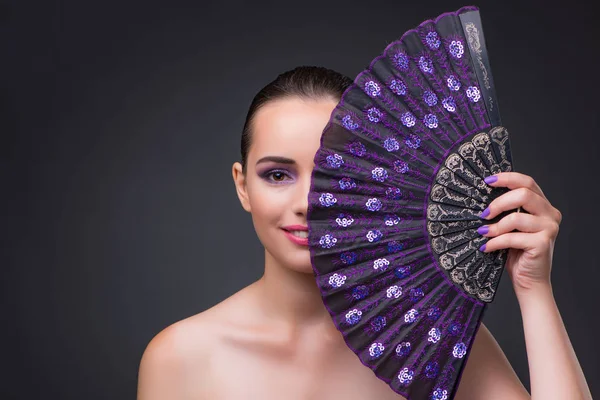 Mujer agradable con ventilador sobre fondo gris — Foto de Stock