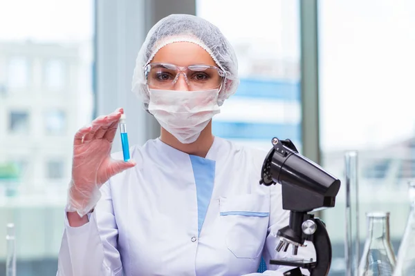 Jovem estudante trabalhando com soluções químicas em laboratório — Fotografia de Stock