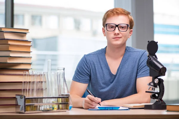 Jovem estudante cansado e exausto se preparando para o exame de química — Fotografia de Stock