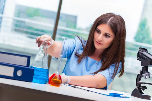 Giovane donna che lavora in laboratorio — Foto Stock