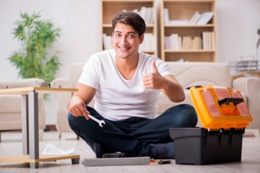 Evdeki rafları monte eden adam