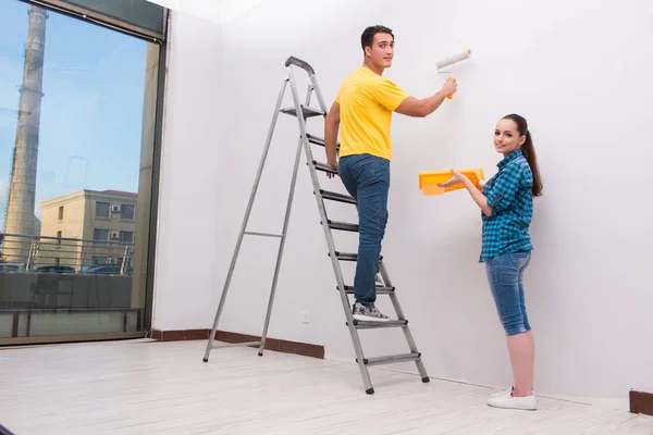 Jovem casal parede de pintura em casa — Fotografia de Stock