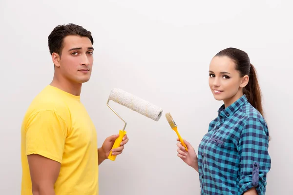 Pareja joven pintando pared en casa —  Fotos de Stock