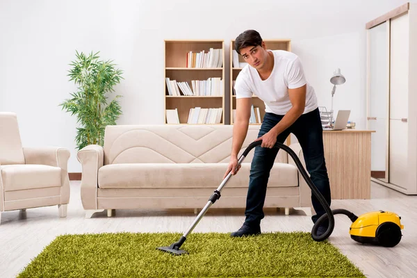 Hombre limpieza casa con aspiradora —  Fotos de Stock