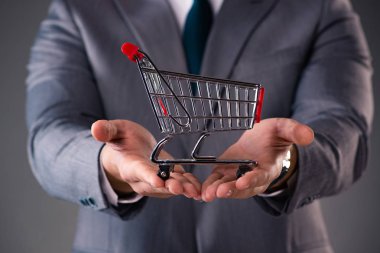 Alışveriş sepeti iş kavramı içinde tutan işadamı