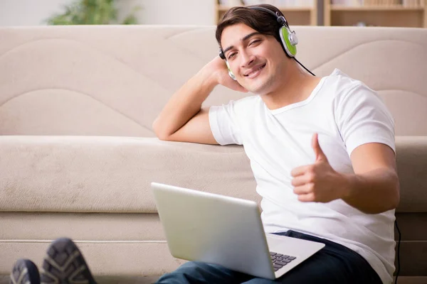 Joven escuchando la música de la computadora portátil —  Fotos de Stock