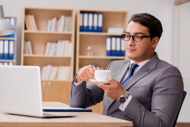 Genç yakışıklı işadamı ofiste çalışıyor.