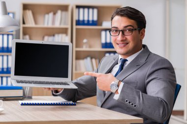 Genç yakışıklı işadamı ofiste çalışıyor.