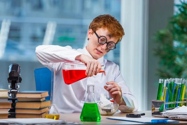 Mladý šílený chemik pracující v laboratoři — Stock fotografie