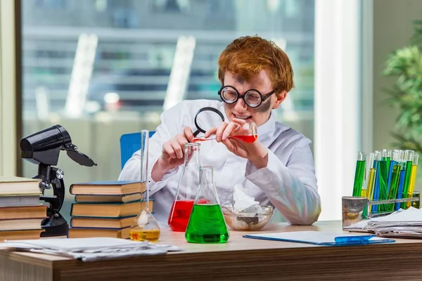 Mladý šílený chemik pracující v laboratoři — Stock fotografie