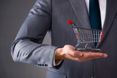 Alışveriş sepeti iş kavramı içinde tutan işadamı