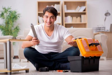 Evdeki rafları monte eden adam