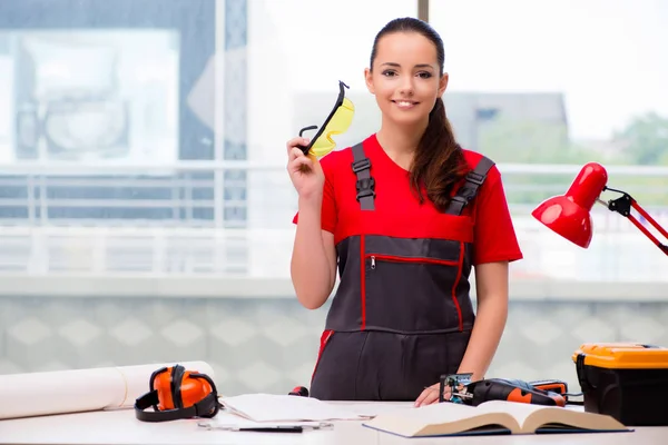 Mujer joven en mono haciendo reparaciones —  Fotos de Stock