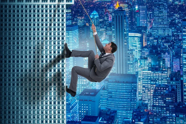 Businessman in challenge concept climbing skyscraper — Stock Photo, Image