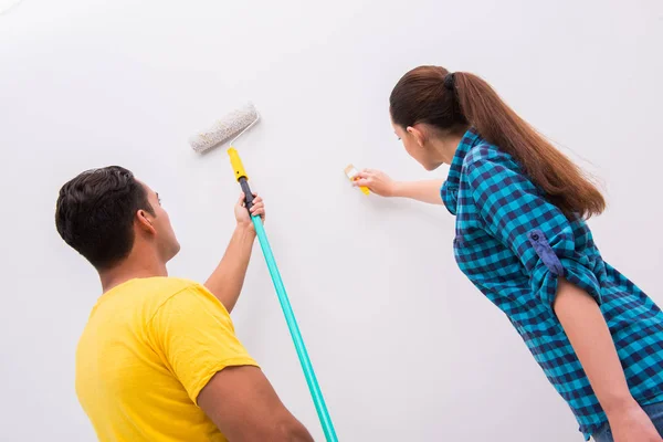 Jovem casal parede de pintura em casa — Fotografia de Stock