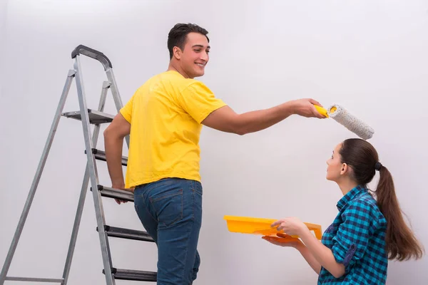 Jovem casal parede de pintura em casa — Fotografia de Stock