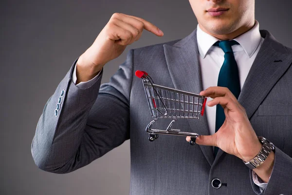 Businessman holding shopping cart in business concept — Stock Photo, Image