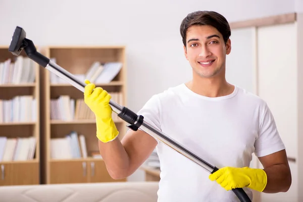 Adam elektrikli süpürgeyle evi temizliyor. — Stok fotoğraf