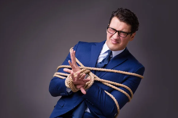 Businessman tied up with rope — Stock Photo, Image