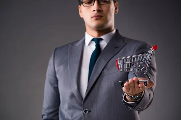 Businessman holding shopping cart in business concept — Stock Photo, Image