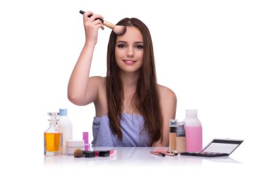 Beyazlar içinde makyaj yapan kadın.