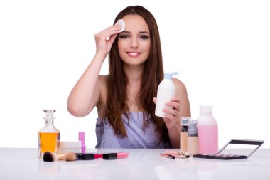 Beyazlar içinde makyaj yapan kadın.