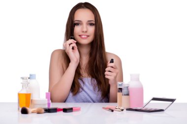 Beyazlar içinde makyaj yapan kadın.