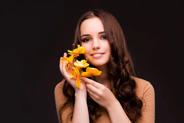 Vacker kvinna med orkidé blomma isolerade på svart — Stockfoto