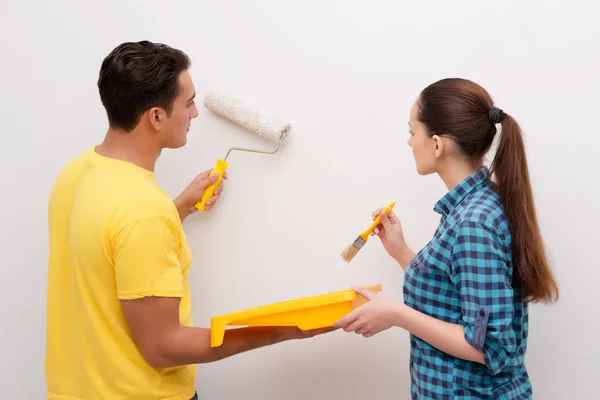 Giovane coppia pittura muro a casa — Foto Stock
