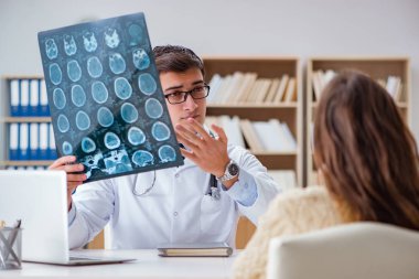 Genç doktor bilgisayardaki röntgen görüntülerine bakıyor.