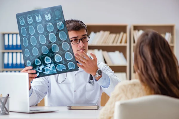 Genç doktor bilgisayardaki röntgen görüntülerine bakıyor.